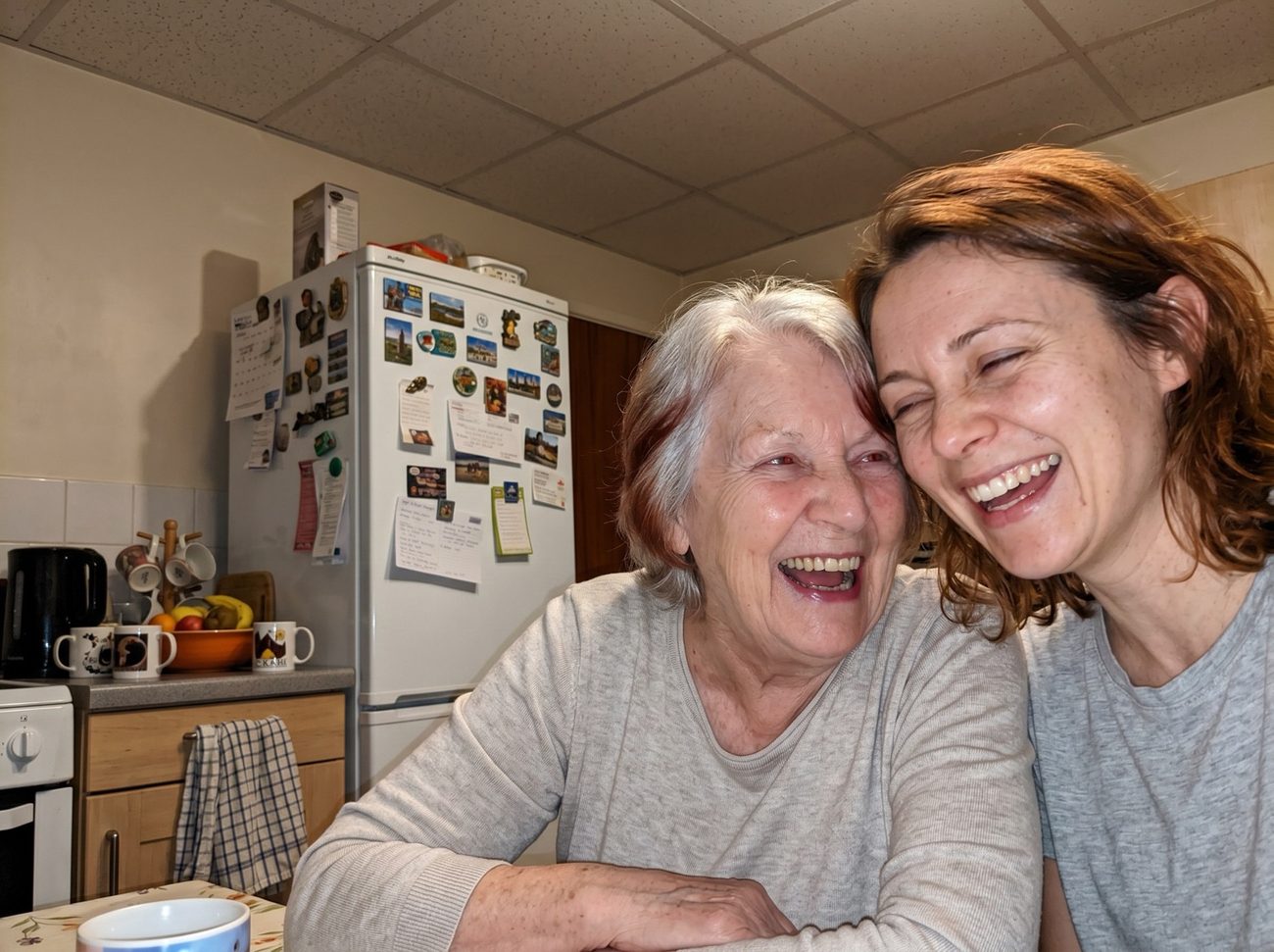 Rachel laughing with her grandmother, a nurse of 41 years, at the kitchen table
